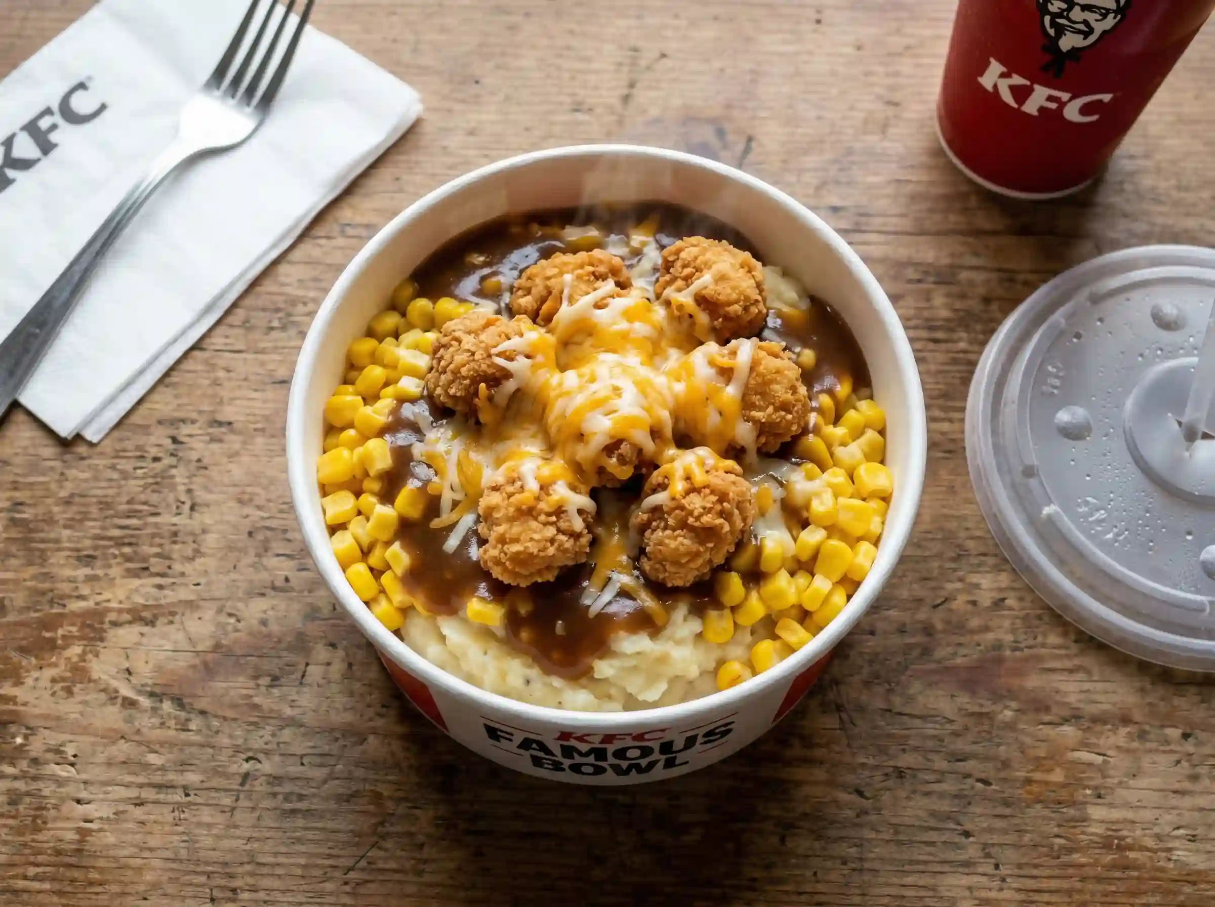 KFC Famous Bowl ingredients layers mashed potatoes gravy corn chicken nuggets cheese